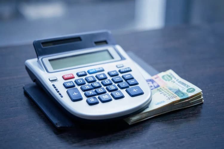 Calculadora e gráficos sobre uma mesa, representando avaliação de empresas.