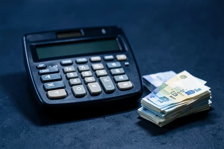 Calculadora e gráficos financeiros em uma mesa de escritório.