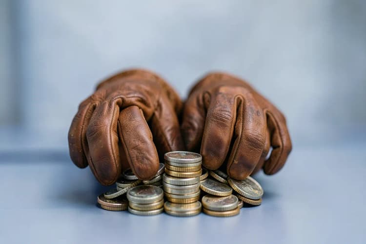 Duas mãos apertando um aperto de mão sobre um fundo desfocado de prédios de escritórios.